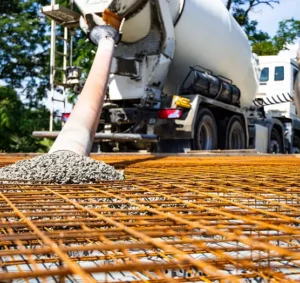 Pouring concrete over rebar grid for flatwork installation including curbs and ramps