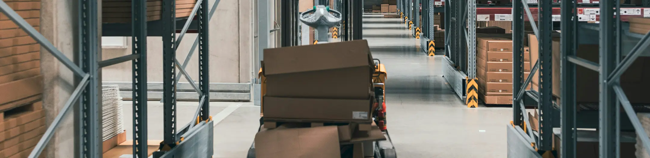 Warehouse interior with shelves and boxes, showing industrial paving needs