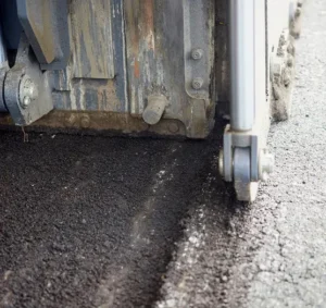 Asphalt milling machine removing old pavement during road surface preparation