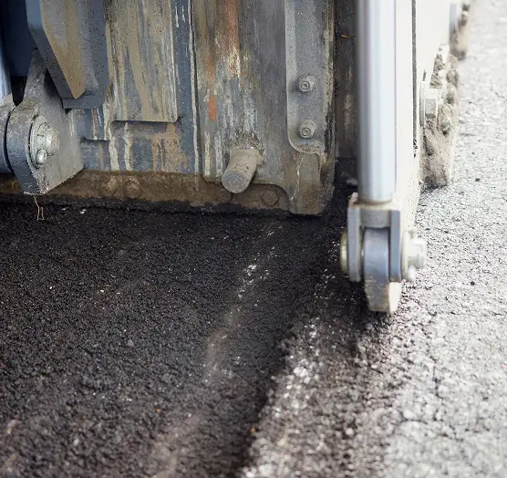 Asphalt milling machine removing old pavement during road surface preparation