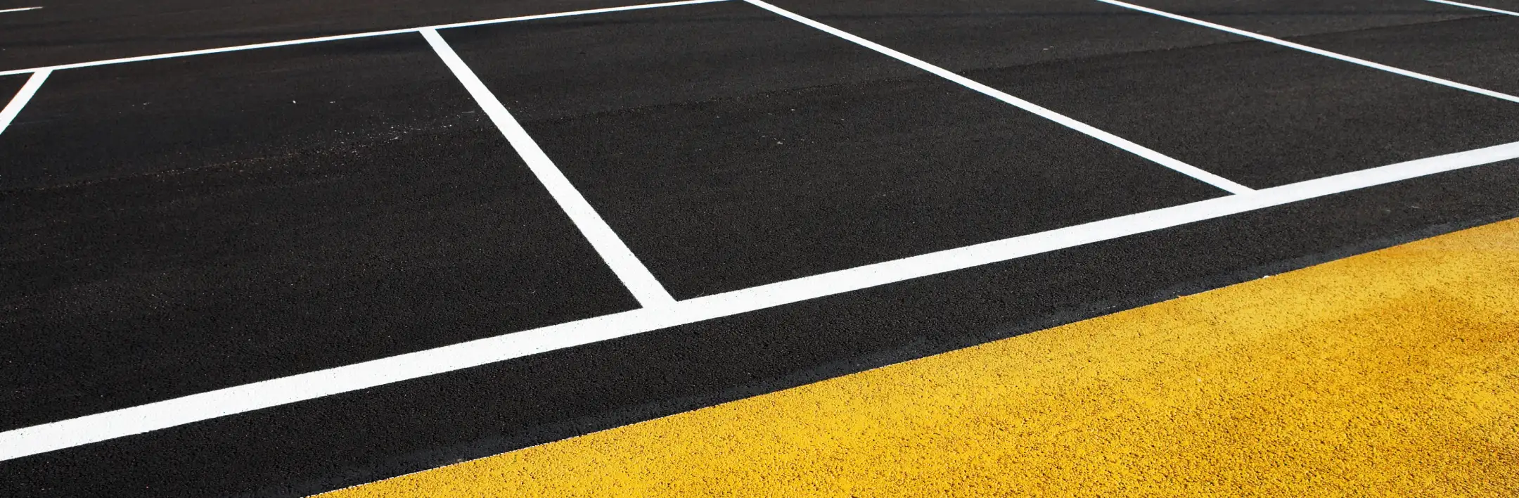 Close-up of fresh asphalt with parking lot striping in Arizona by Valor Paving