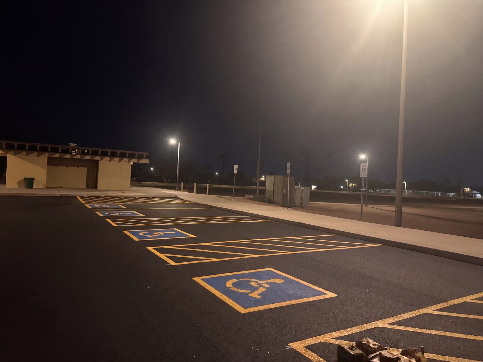 ADA-compliant handicap parking spaces with blue logos and yellow access aisles at El Prado Park