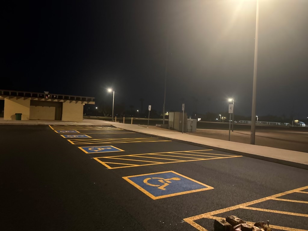 ADA-compliant handicap parking spaces with blue logos and yellow access aisles at El Prado Park
