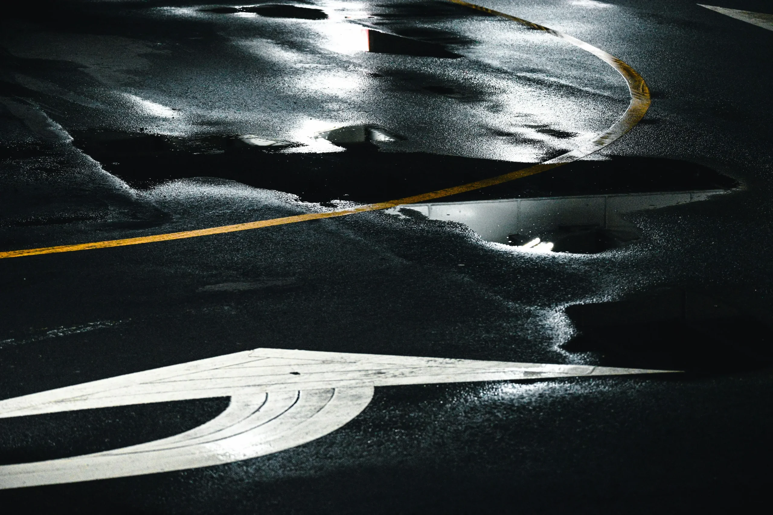 Standing water pooling in a commercial parking lot with drainage failure